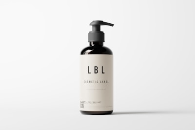 A dark brown bottle with a pump dispenser, featuring a minimalistic label displaying the text 'LBL Cosmetic Label' and additional information. The background is plain and light-colored, creating a clean, modern appearance.