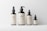 Four cosmetic bottles of varying sizes are neatly arranged against a plain background. Each bottle features a minimalist beige label with the text 'LBL Cosmetic Label' and a small QR code at the bottom.