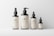 Four cosmetic bottles of varying sizes are neatly arranged against a plain background. Each bottle features a minimalist beige label with the text 'LBL Cosmetic Label' and a small QR code at the bottom.