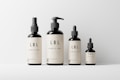 Four cosmetic bottles of varying sizes are neatly arranged against a plain background. Each bottle features a minimalist beige label with the text 'LBL Cosmetic Label' and a small QR code at the bottom.