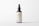 A minimalistic cosmetic bottle with a pump dispenser is positioned centrally against a plain white background. The bottle is dark in color with a simple, elegant label that reads 'LBL COSMETIC LABEL'. The design emphasizes clean lines and simplicity, highlighting the brand's focus on elegance and modern aesthetics.