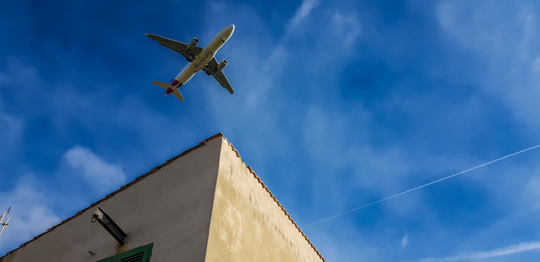 an airplane is flying over a building,