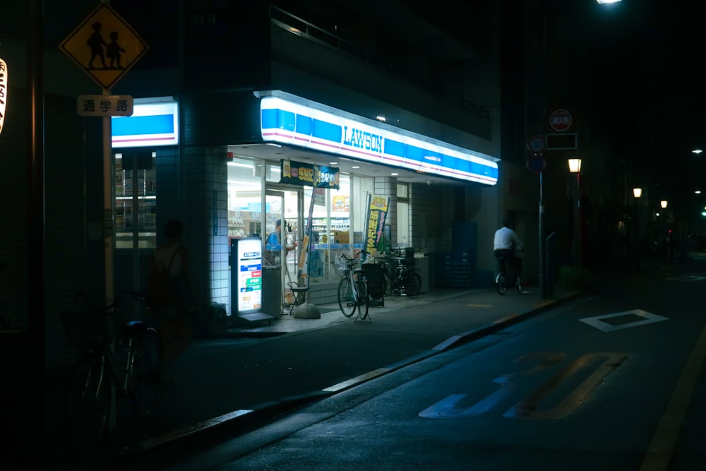 a gas station at night with a bicycle parked in front of it