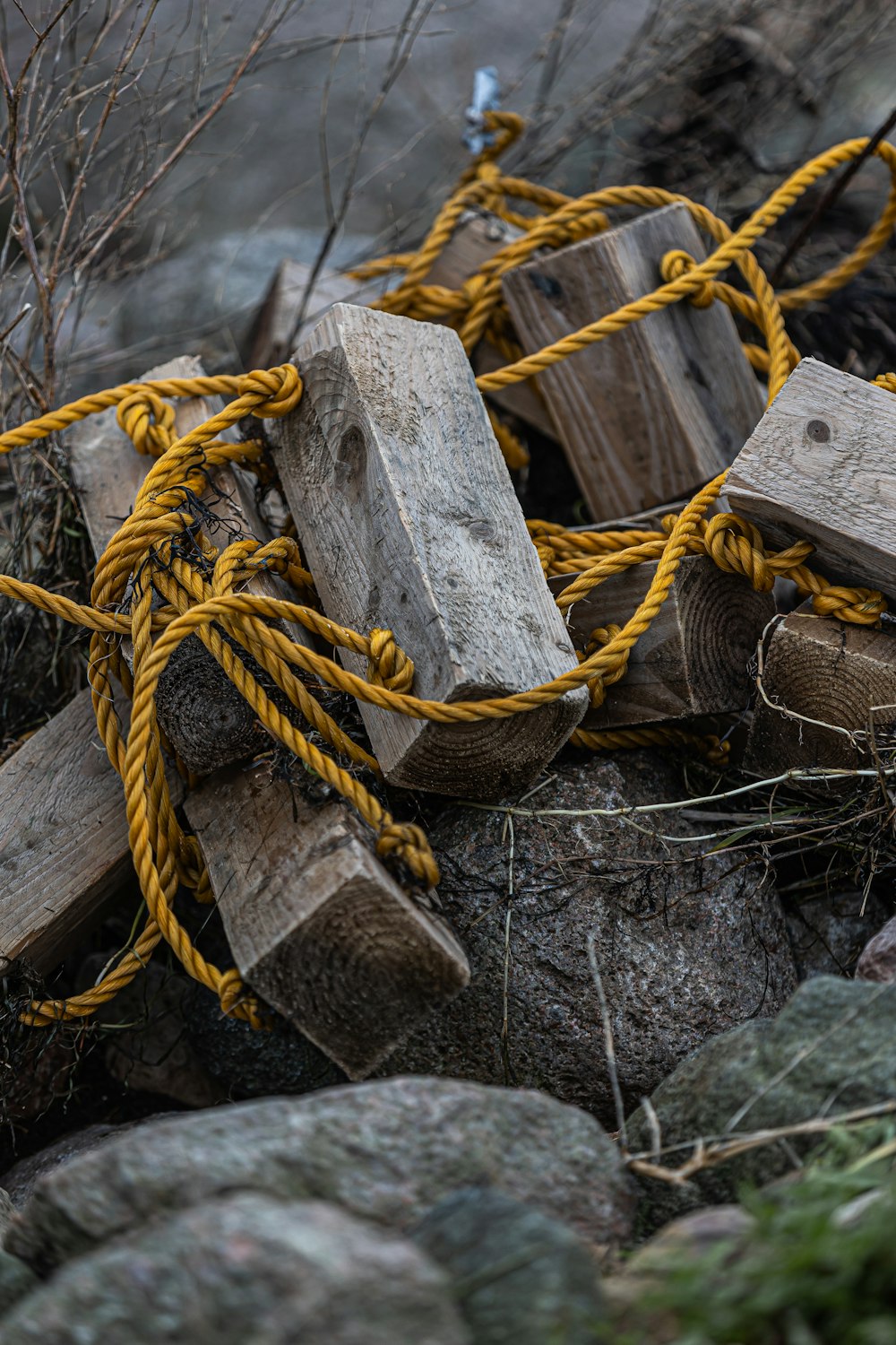 a pile of wood blocks and ropes on a rocky hillside