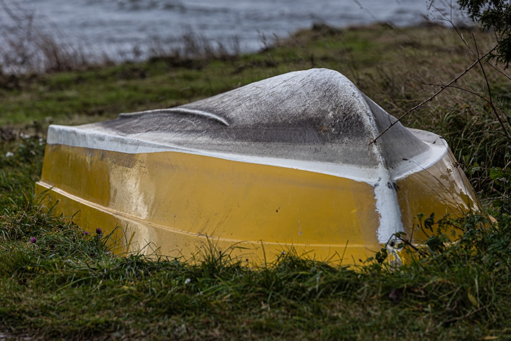 un bateau jaune assis au sommet d’un champ verdoyant