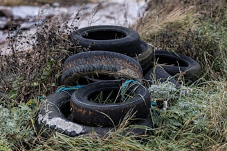 a pile of old tires sitting in the grass