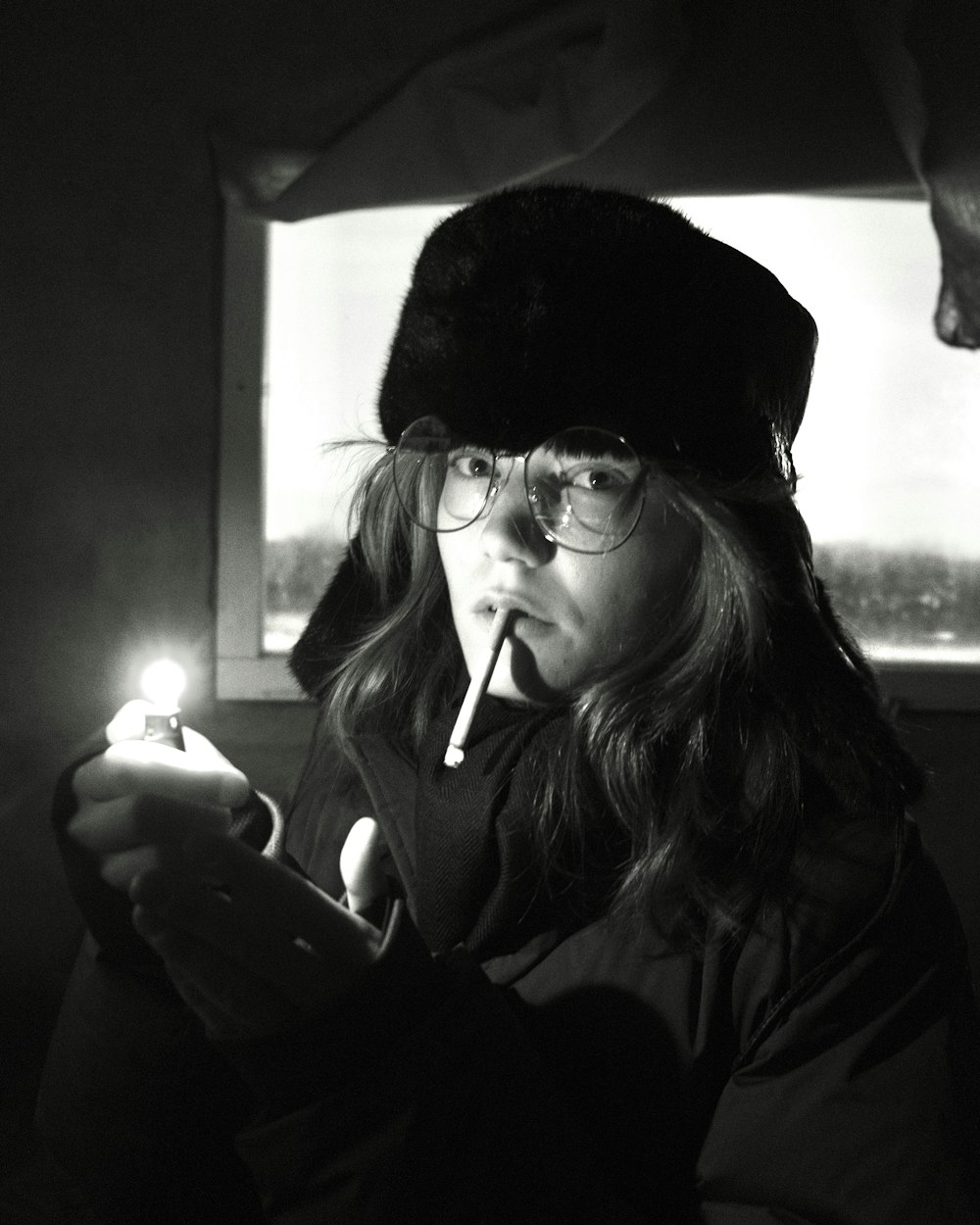 a woman smoking a cigarette while wearing a hat