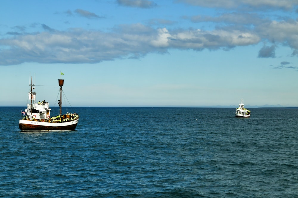 a couple of boats floating on top of a large body of water