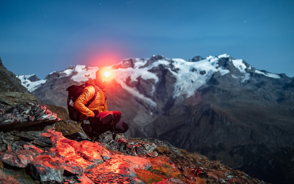 山の頂上で明かりのそばに座る男