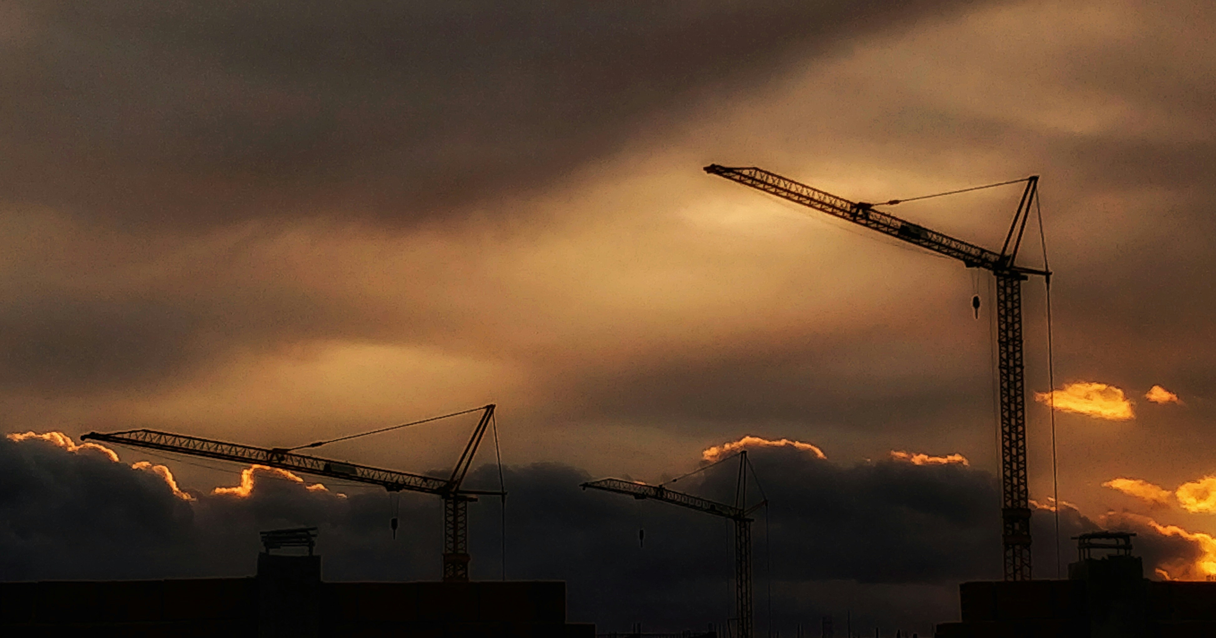 a crane is silhouetted against a cloudy sky