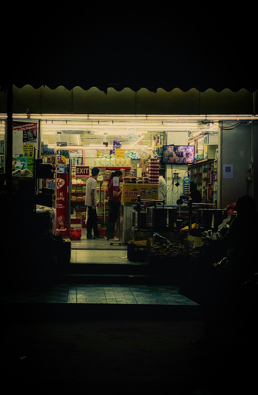 a man standing in front of a store at night