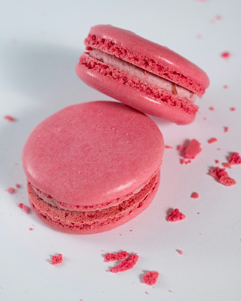 a couple of pink macaroons sitting on top of a table