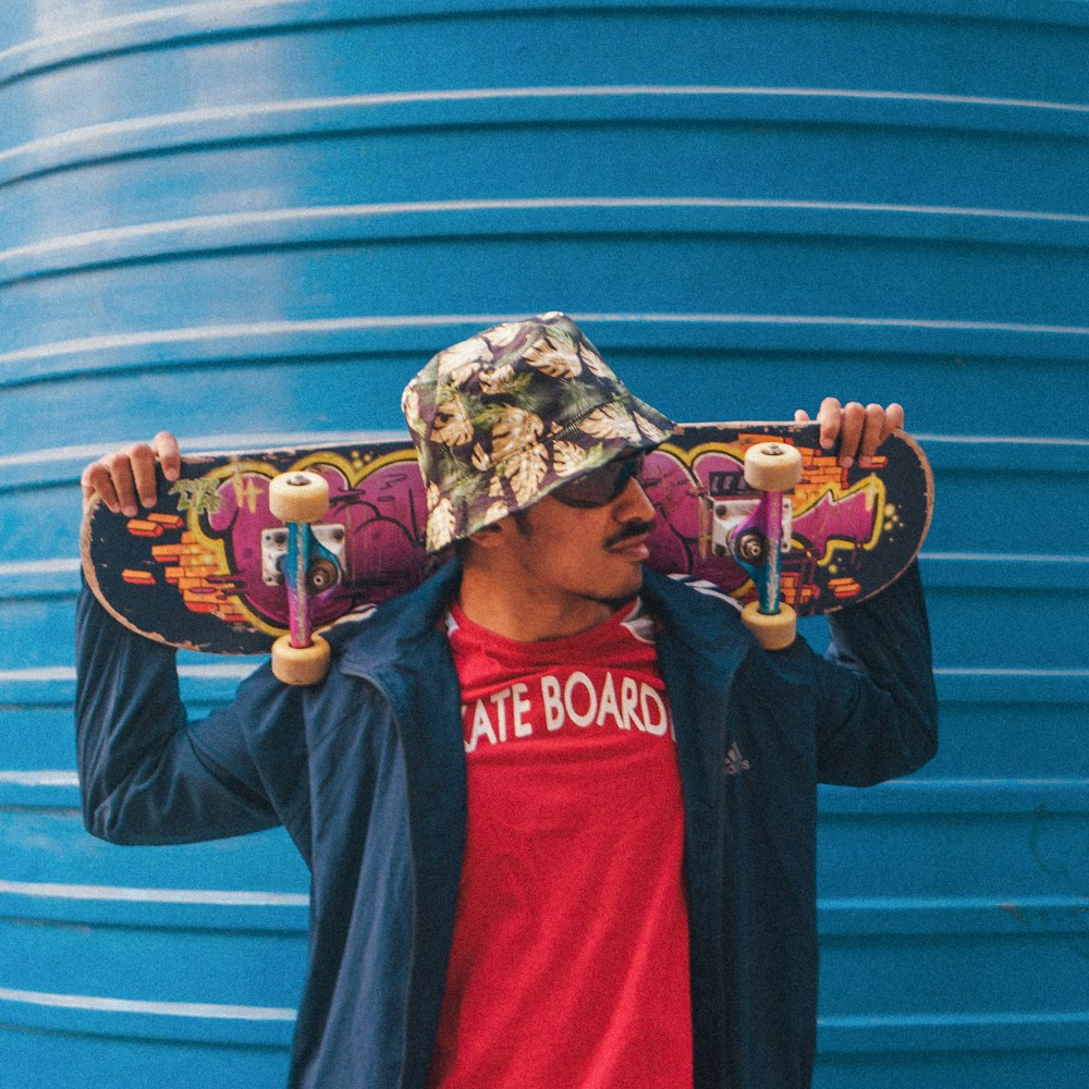 a man holding a skateboard over his head