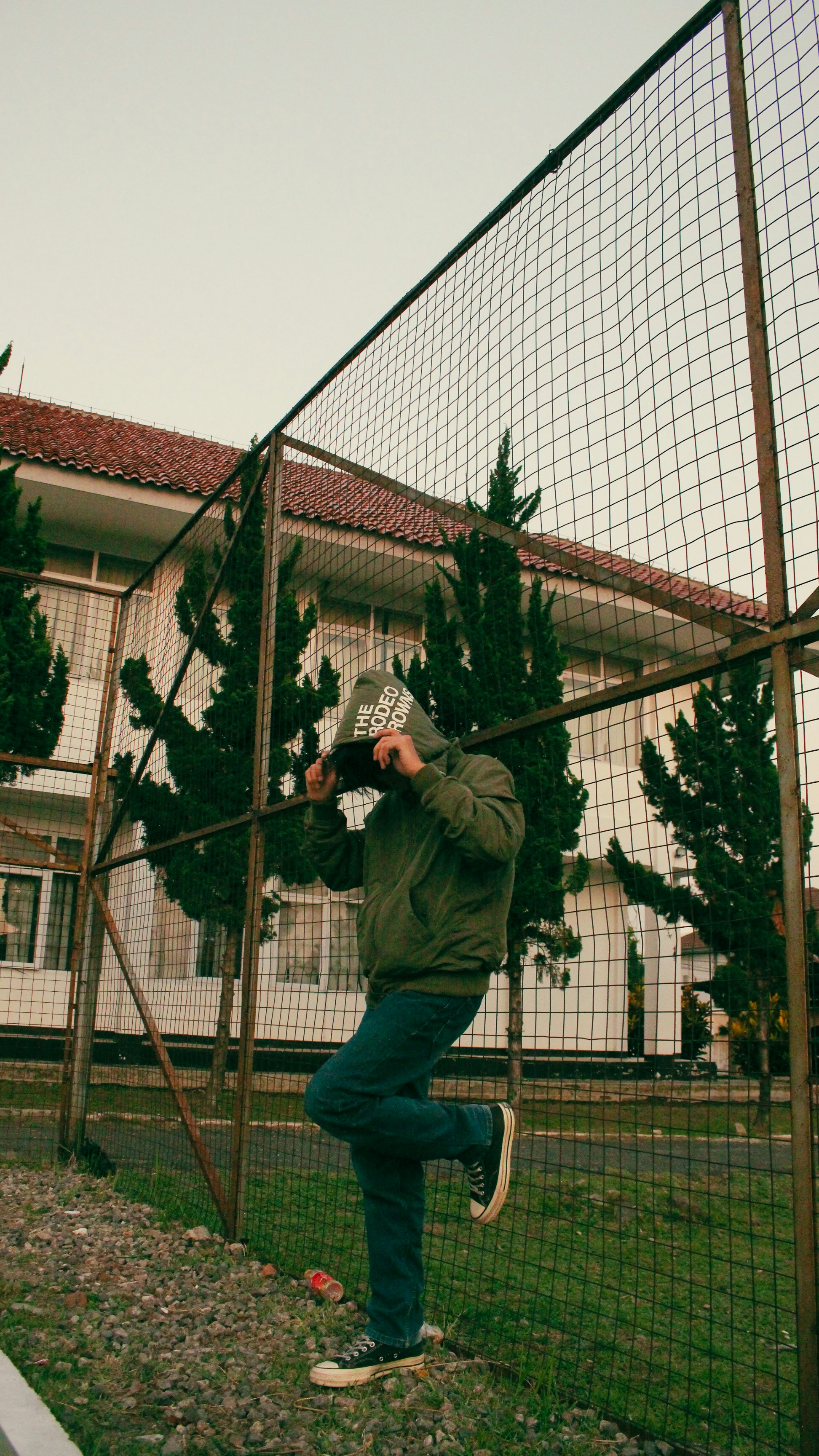 a man taking a picture of himself through a fence