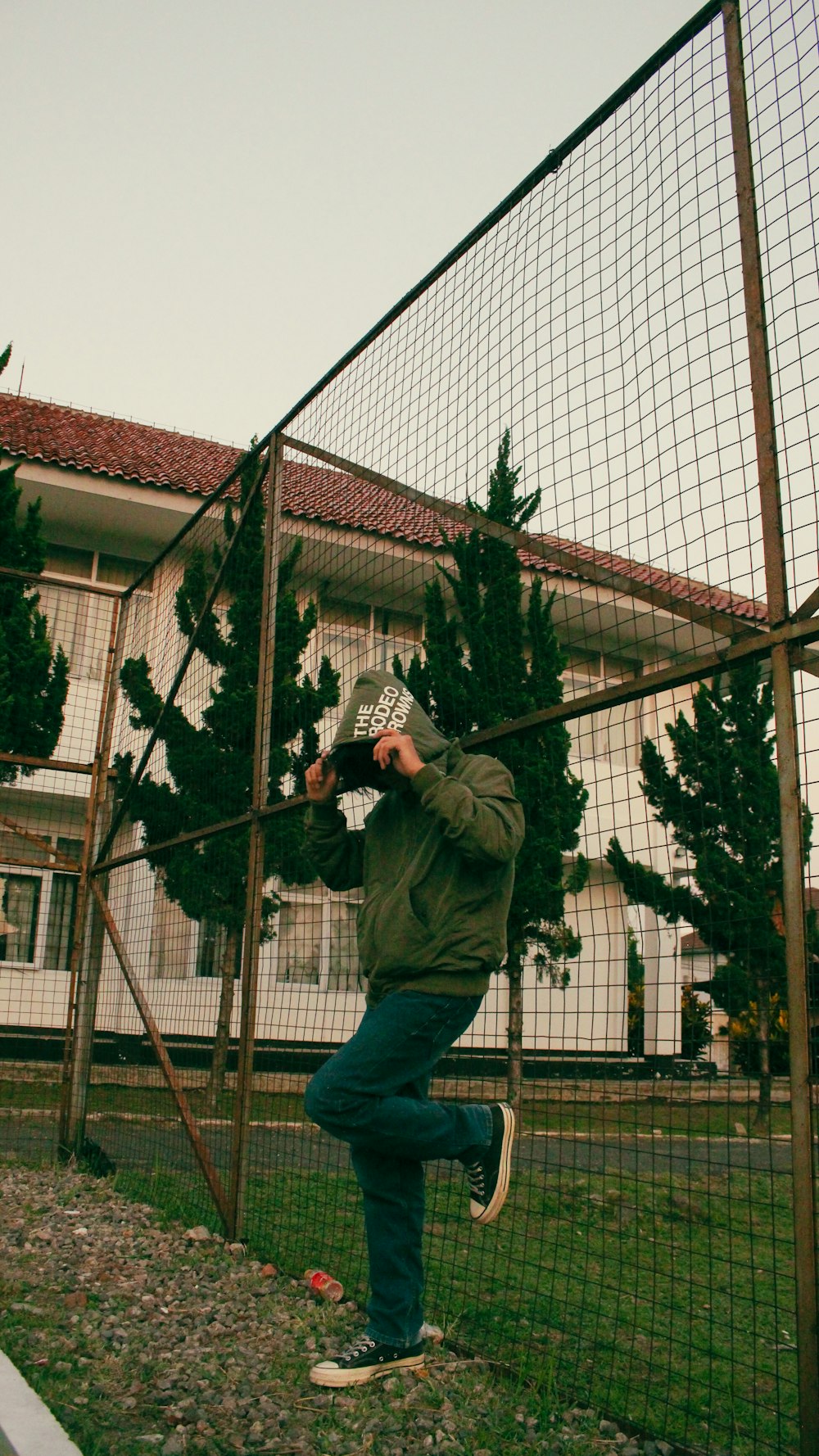 a man taking a picture of himself through a fence