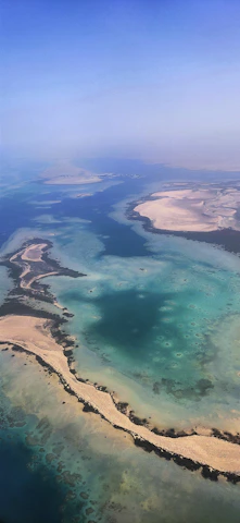Aerial view of turquoise ocean waters and white sandy beaches below