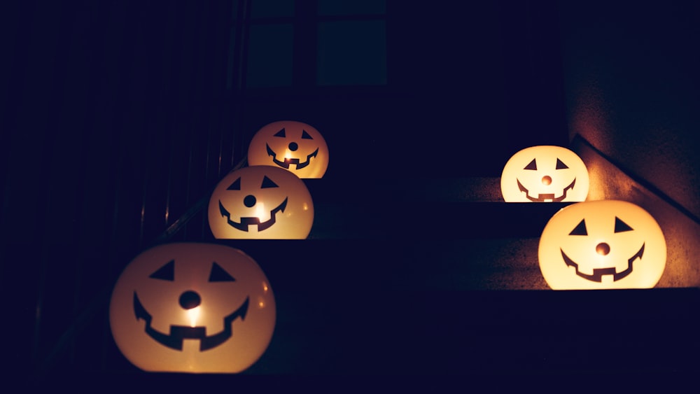 a group of lighted pumpkins sitting on top of a step