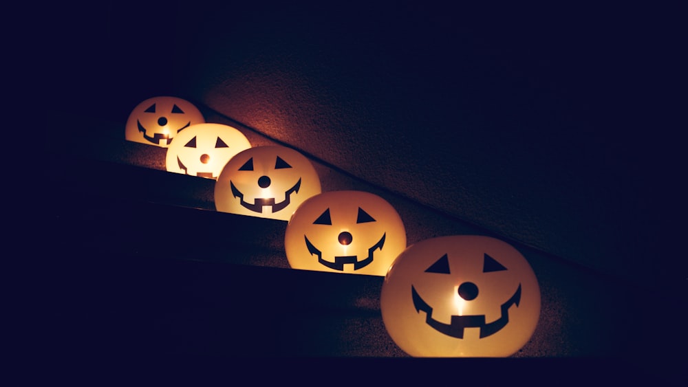 a row of lighted pumpkins with faces on them