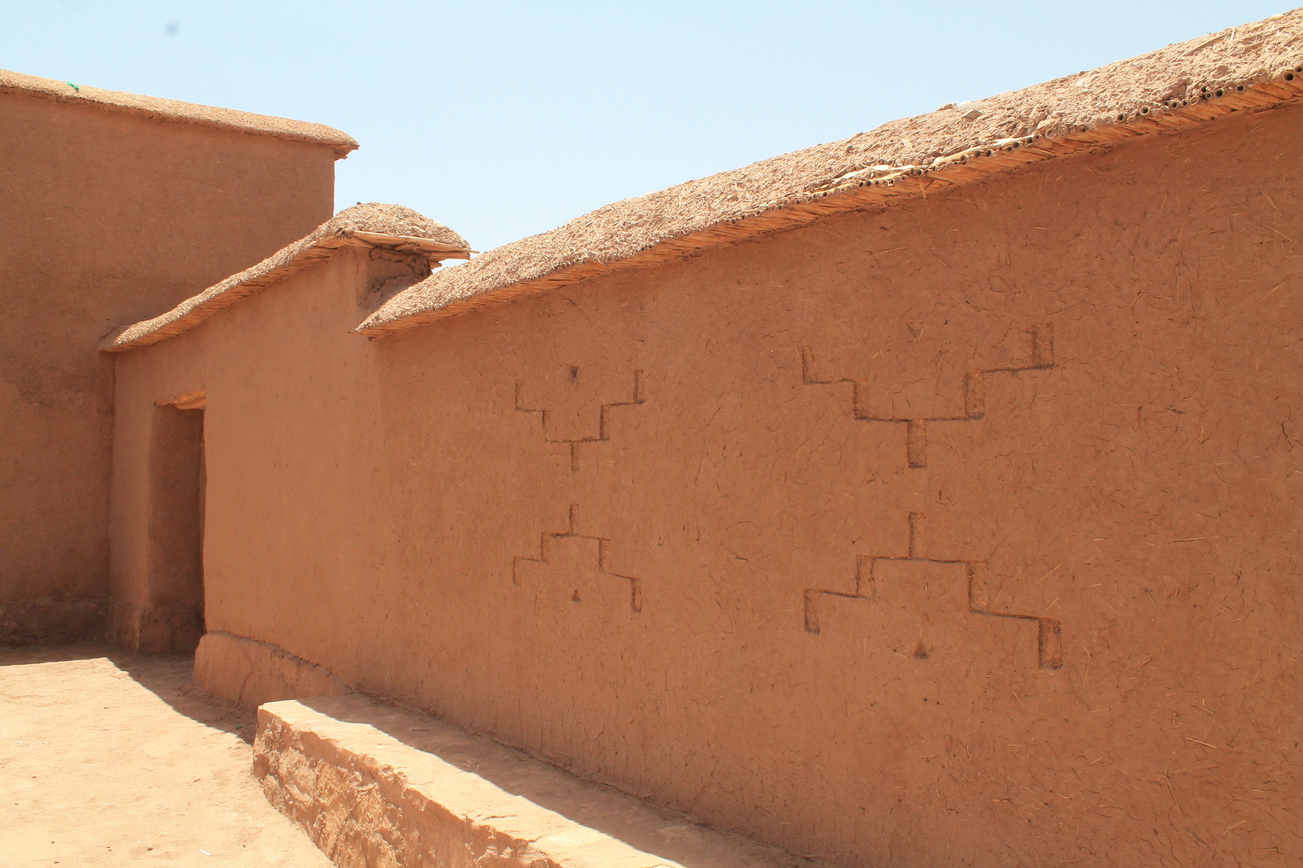 a building with a thatched roof and a stone wall