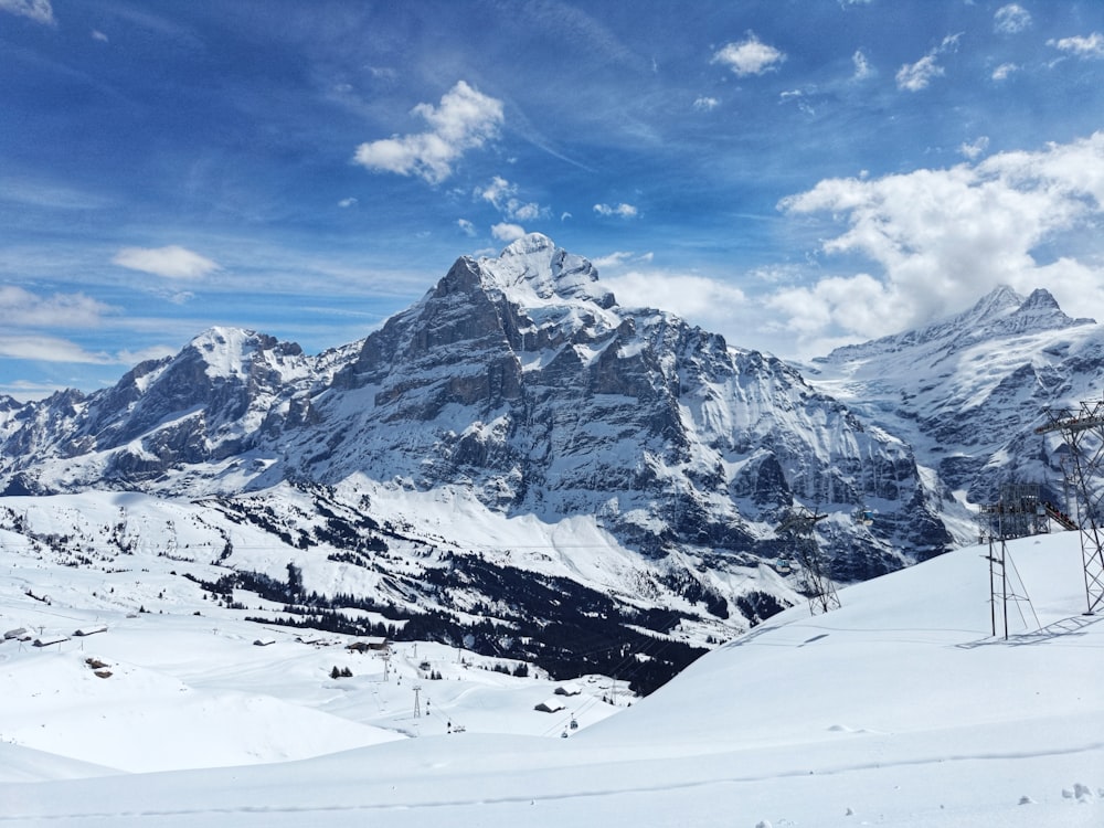 a snow covered mountain with a ski lift in the foreground