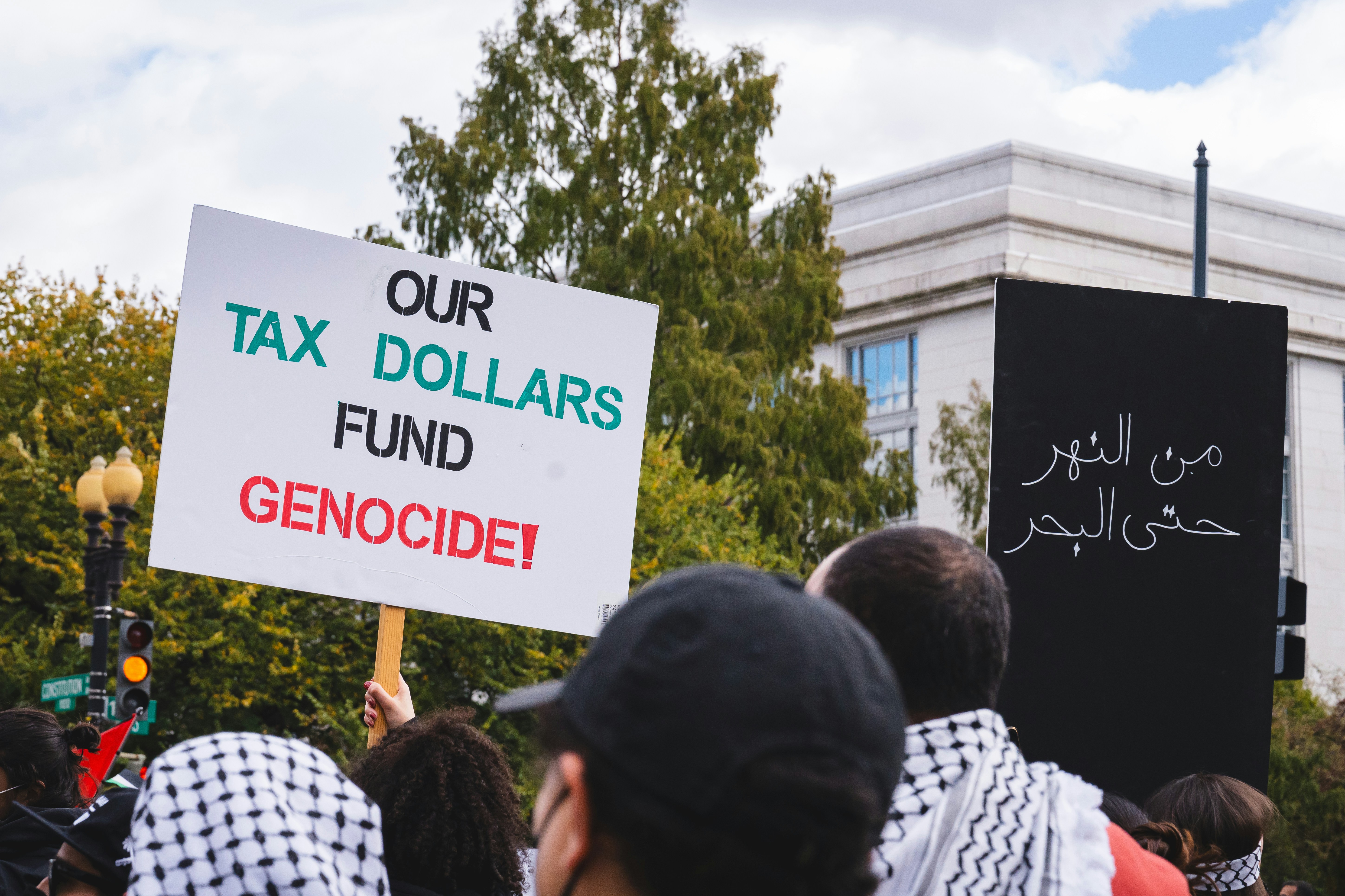 a group of people holding signs in front of a building, 