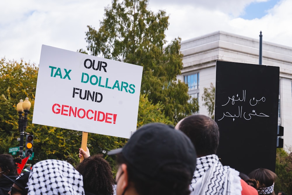 a group of people holding signs in front of a building