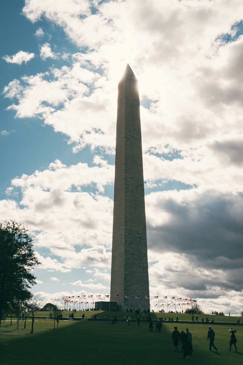 a tall obelisk in the middle of a grassy field