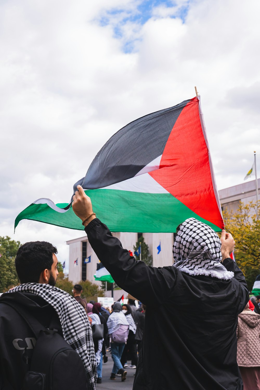 a man holding a flag in front of a crowd of people