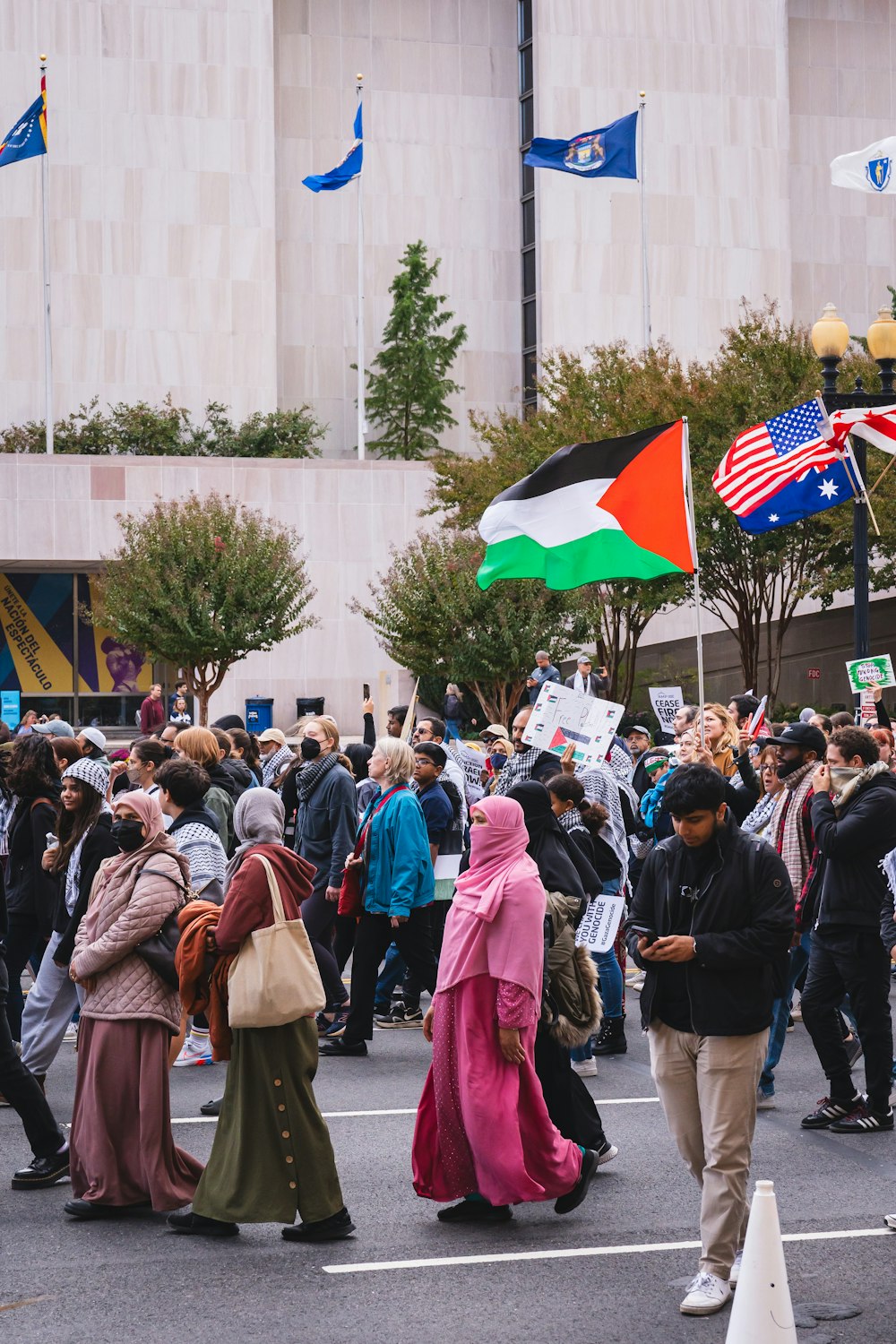 a group of people walking down a street holding flags