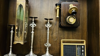 a collection of old fashioned telephones and candles