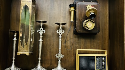 a collection of old fashioned telephones and candles