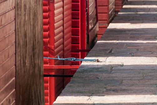 A close-up of a hand rod resting on a wooden dock with morning light reflecting off the water.