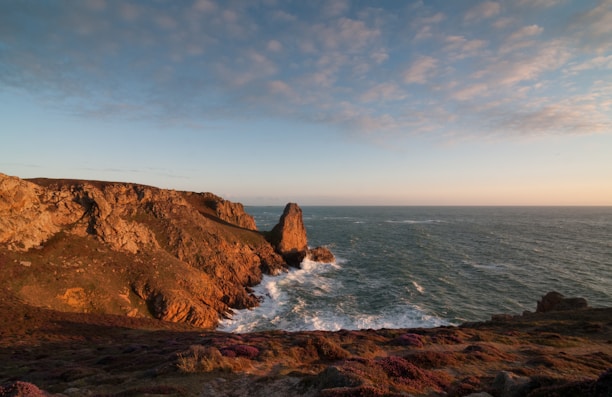 Sunset over rugged coastal cliffs with crashing waves, capturing the spirit of Betty's Bay.