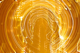 A vivid display of swirling lights creating circular patterns, resembling a tunnel or vortex effect with a golden hue.