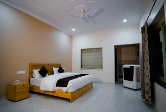Cozy air-conditioned room with neat bedding and soft lighting at Mallikarjuna Sadan