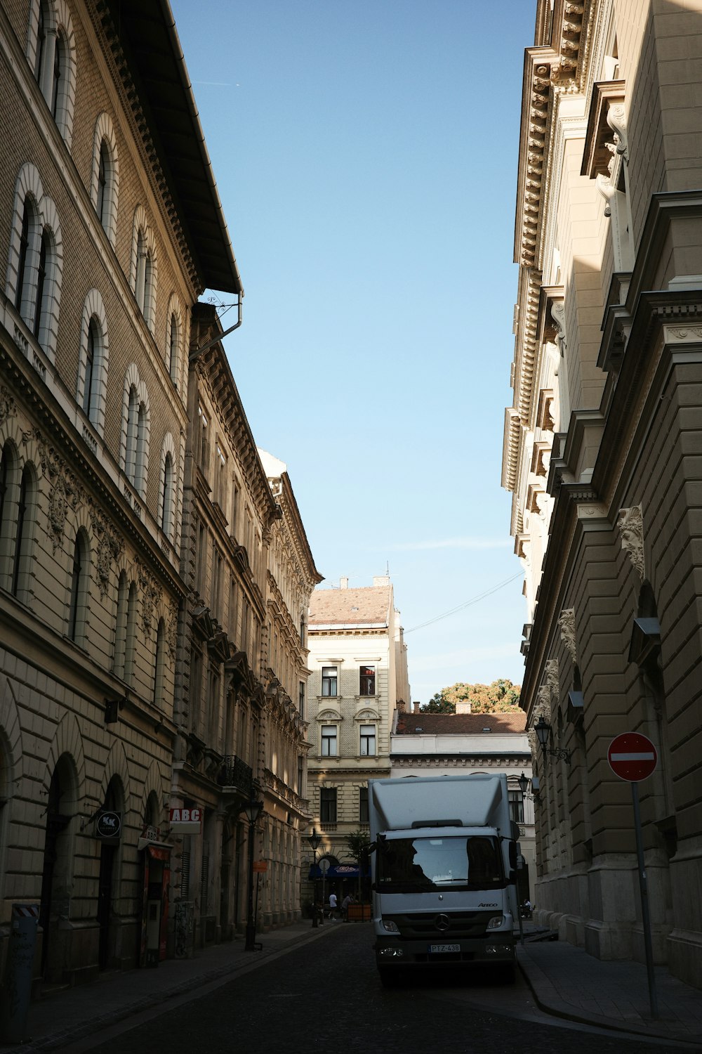 a truck driving down a street next to tall buildings