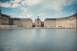 Bordeaux Place de la Bourse reflected in the Miroir d'eau water mirror on the Garonne quayside at dusk