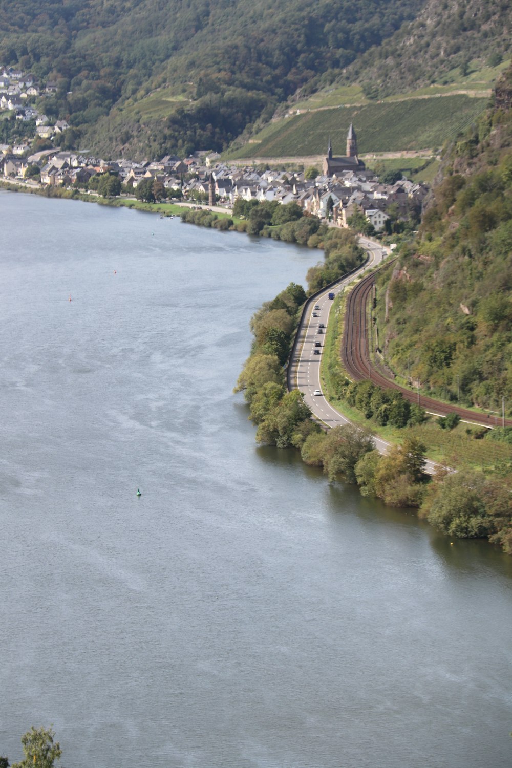 a large body of water surrounded by a lush green hillside