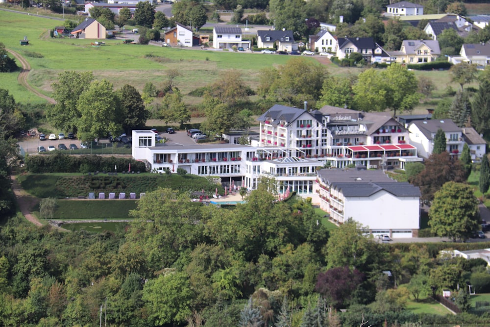 an aerial view of a large white building surrounded by trees