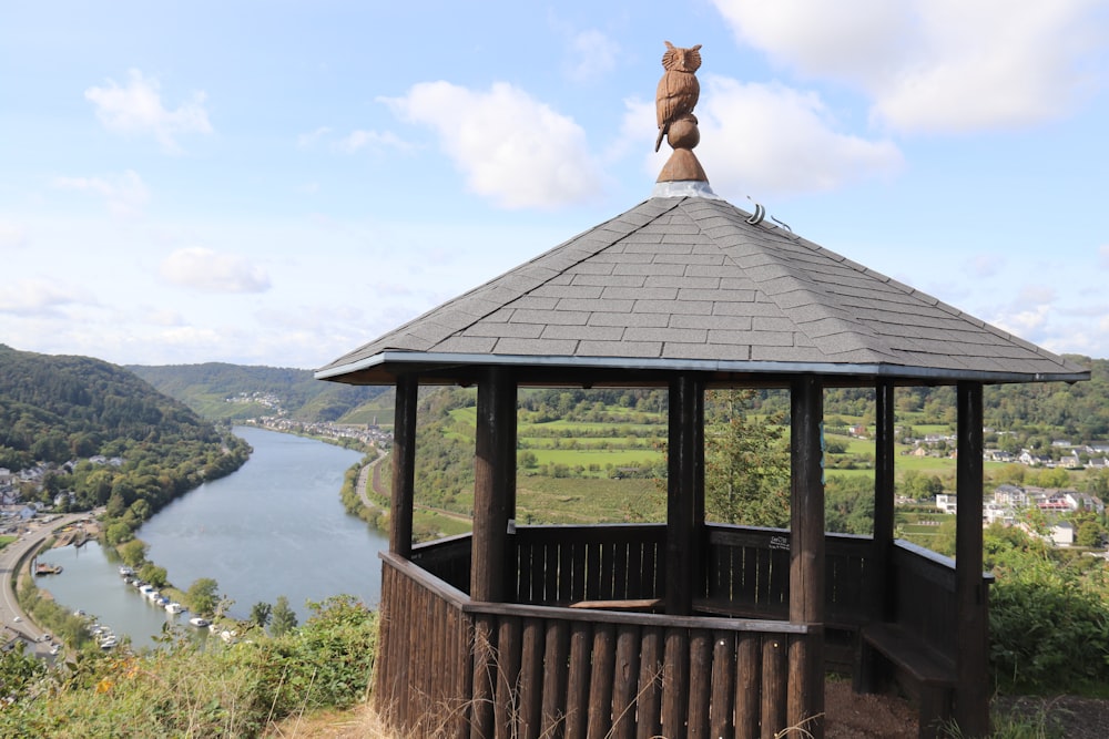 a gazebo on top of a hill overlooking a river
