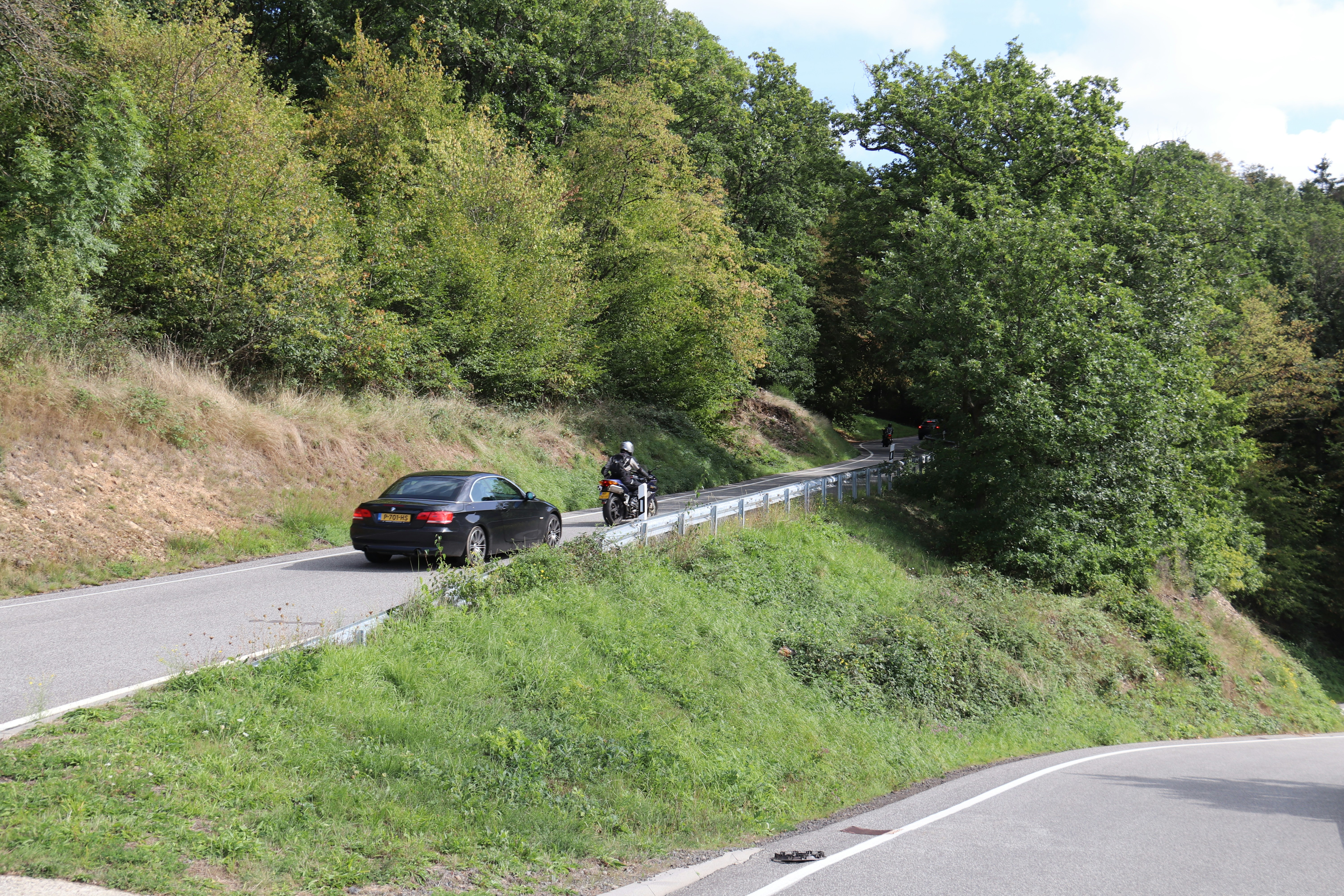 a car and a motorcycle on a road