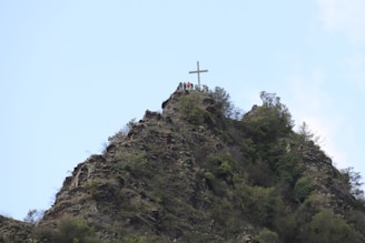 Sunrise view over the hilltop cross at Saint Thomas Mount, with pilgrims beginning their ascent.