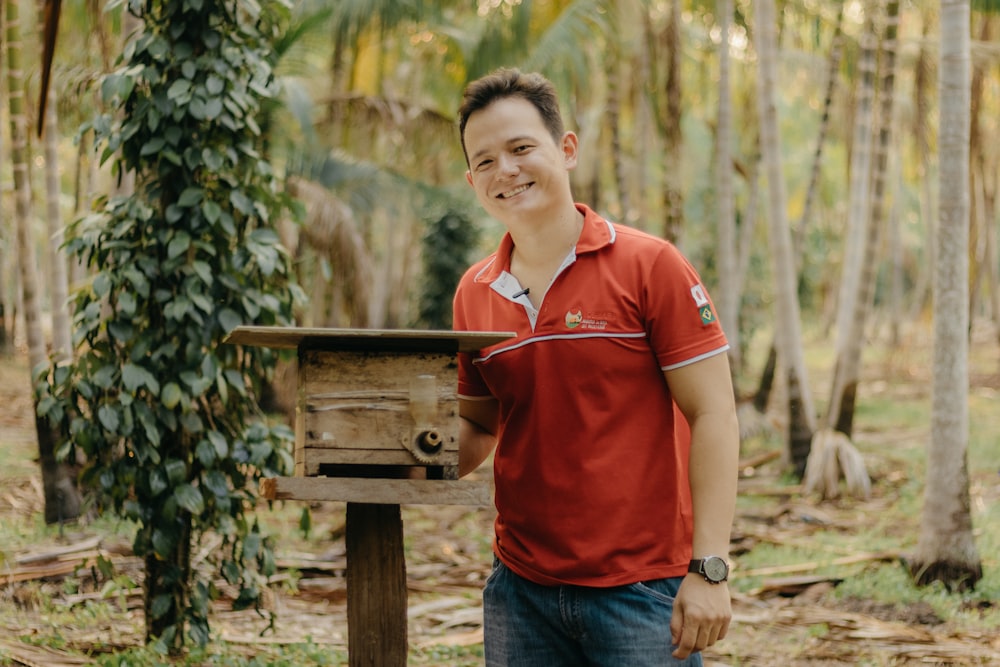 a man standing next to a mailbox in a forest