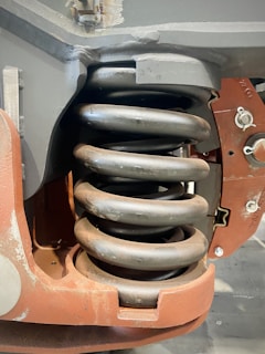 A close-up of a broken spring being replaced by a technician.