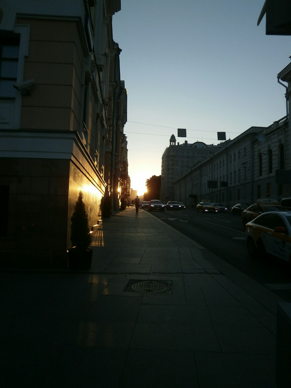 the sun is setting on a city street