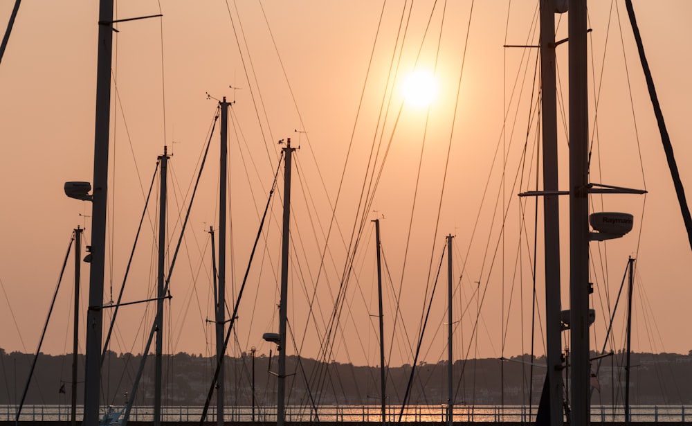 the sun is setting over a bunch of sailboats