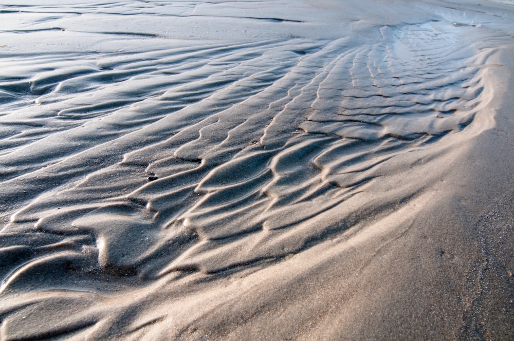 a sandy beach with waves coming in from the ocean