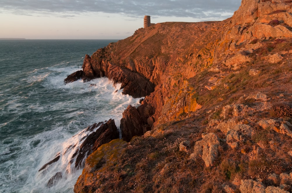 a lighthouse on a cliff overlooking the ocean