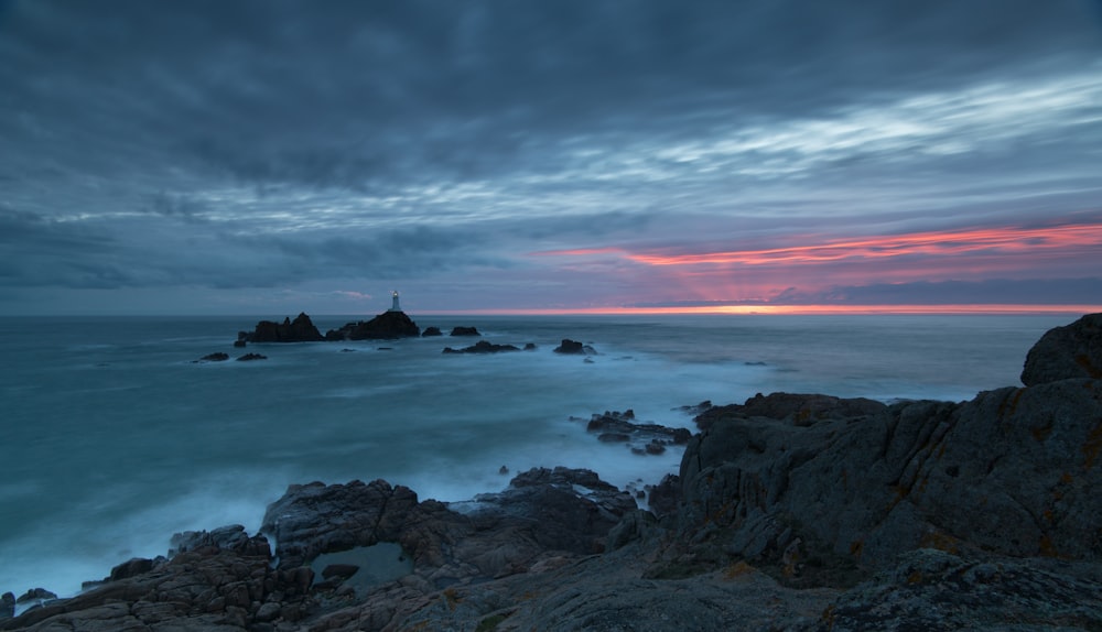 a view of the ocean with a lighthouse in the distance