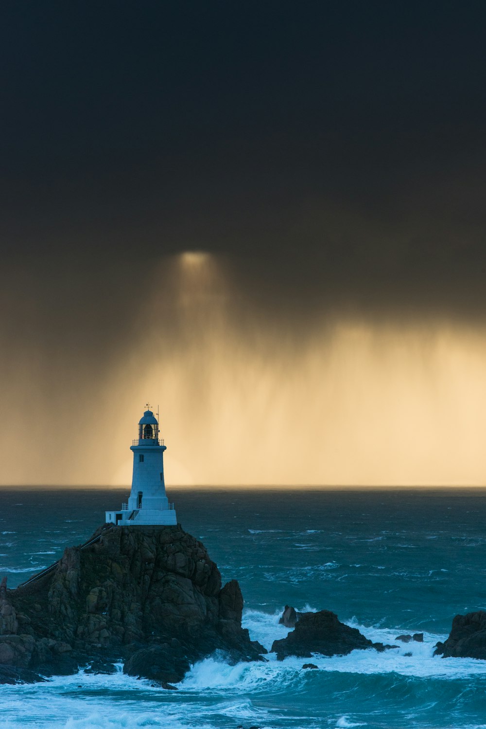 ein Leuchtturm, der auf einem Felsen in der Nähe des Ozeans sitzt